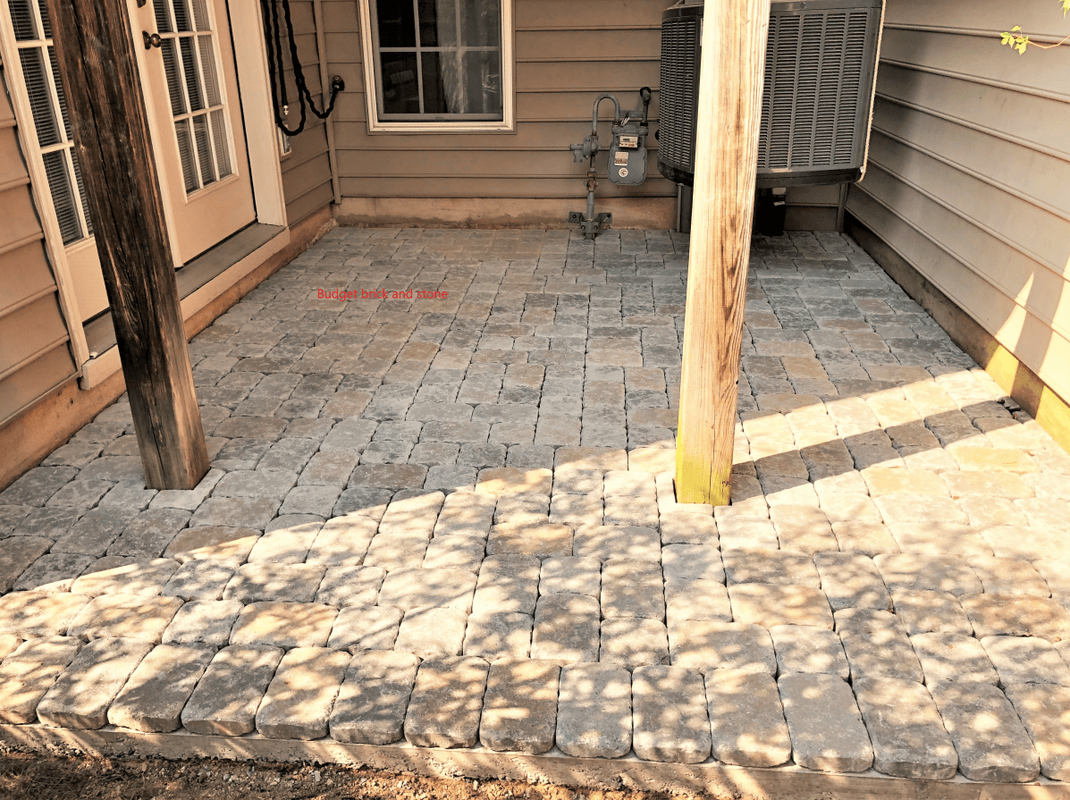 Paver patio on town house. AC unit lifted to run pavers under it.